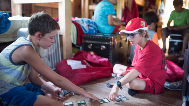 Campers playing with trading cards in their cabin